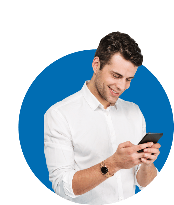 גבר מחייך בחולצה לבנה מסתכל על הטלפון הנייד שלו.